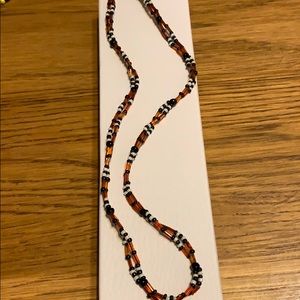 18” necklace with orange, black, and white beads.
